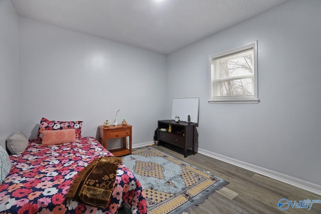 bedroom featuring baseboards and wood finished floors