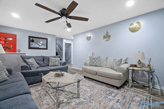 living area with ceiling fan, recessed lighting, stairway, wood finished floors, and baseboards