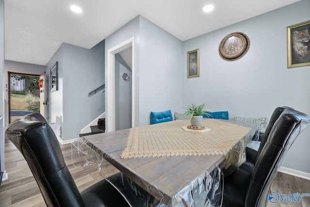 dining area with baseboards, recessed lighting, wood finished floors, and stairs
