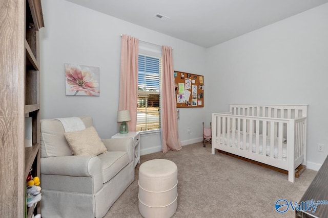 carpeted bedroom featuring a crib, visible vents, and baseboards