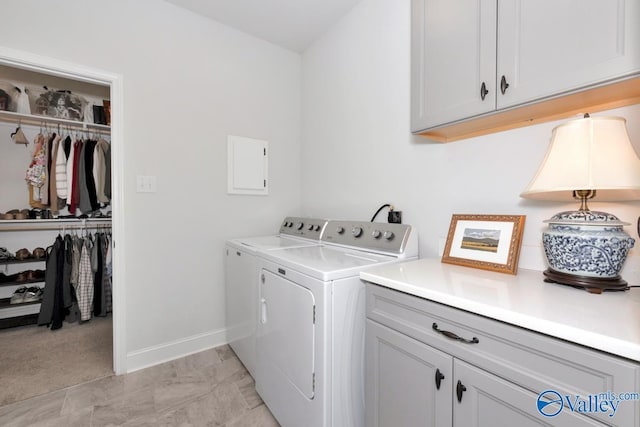 washroom featuring baseboards, cabinet space, and washer and dryer