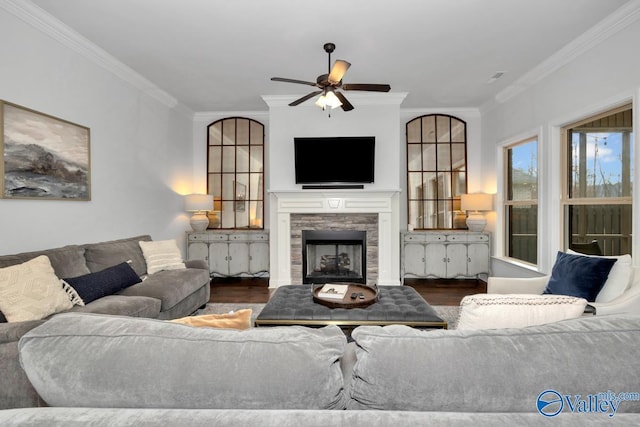 living room featuring a fireplace, wood finished floors, a ceiling fan, and crown molding