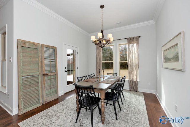 dining area with dark wood-style floors, crown molding, baseboards, and an inviting chandelier