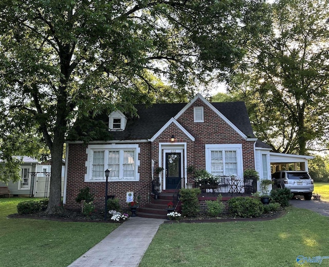 view of front of home featuring aphalt driveway, a front yard, and brick siding