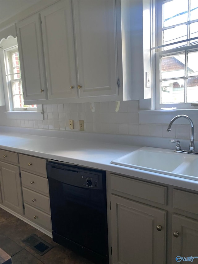 kitchen featuring black dishwasher, white cabinets, sink, and backsplash