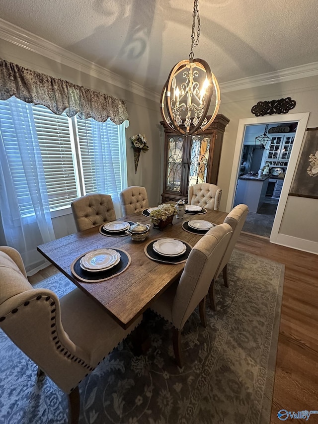 dining room with a textured ceiling, a notable chandelier, and wood finished floors