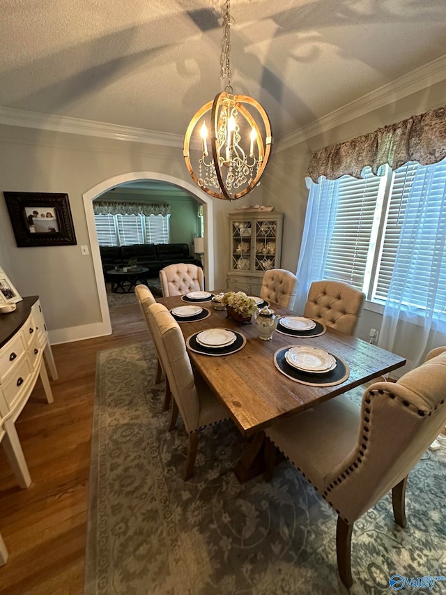 dining room featuring hardwood / wood-style floors, a textured ceiling, and ornamental molding