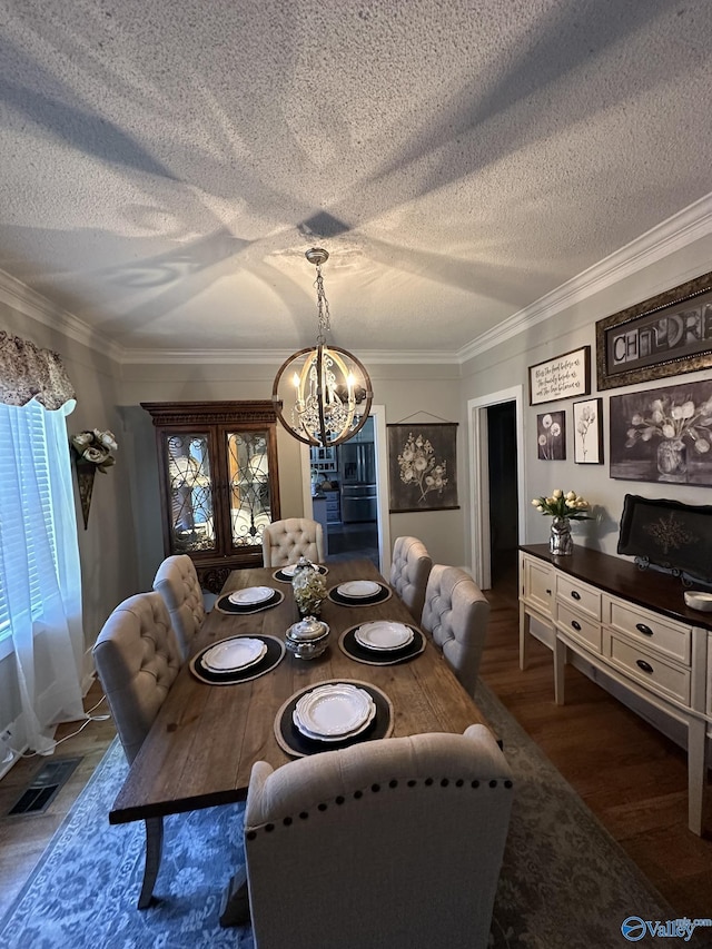 dining area with a chandelier, visible vents, ornamental molding, a textured ceiling, and wood finished floors