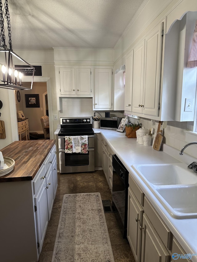 kitchen with an inviting chandelier, wood counters, stainless steel appliances, white cabinets, and a sink