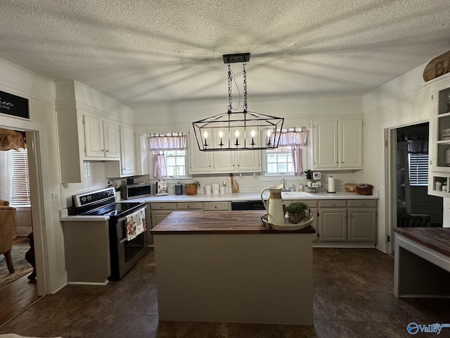 kitchen with wooden counters, appliances with stainless steel finishes, a kitchen island, and plenty of natural light