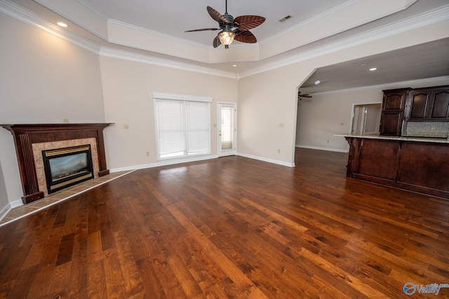 unfurnished living room with visible vents, a fireplace, dark wood finished floors, and a ceiling fan