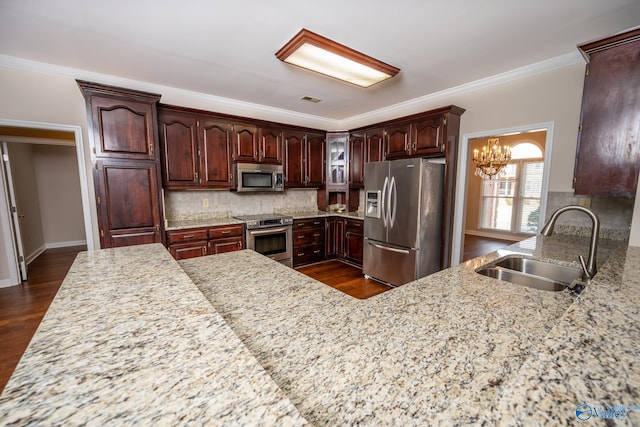 kitchen featuring ornamental molding, a sink, tasteful backsplash, dark wood finished floors, and stainless steel appliances