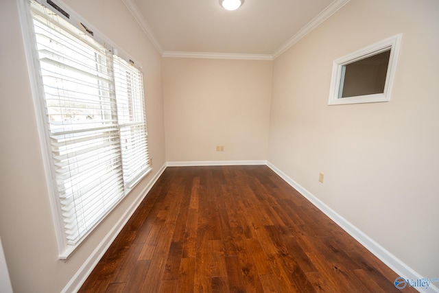 empty room featuring ornamental molding, baseboards, and dark wood-style flooring