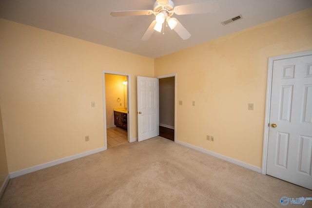 unfurnished bedroom featuring light carpet, visible vents, connected bathroom, and baseboards