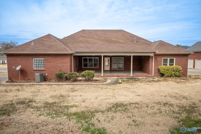 back of property featuring cooling unit, brick siding, roof with shingles, and crawl space