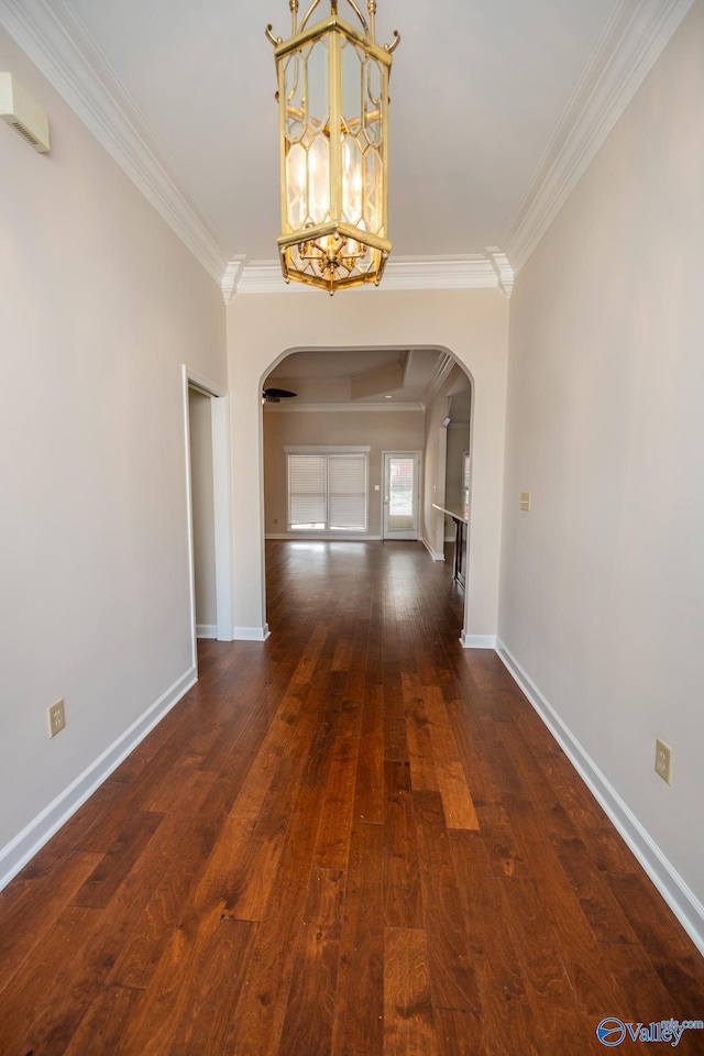 interior space featuring arched walkways, dark wood-style flooring, and ornamental molding