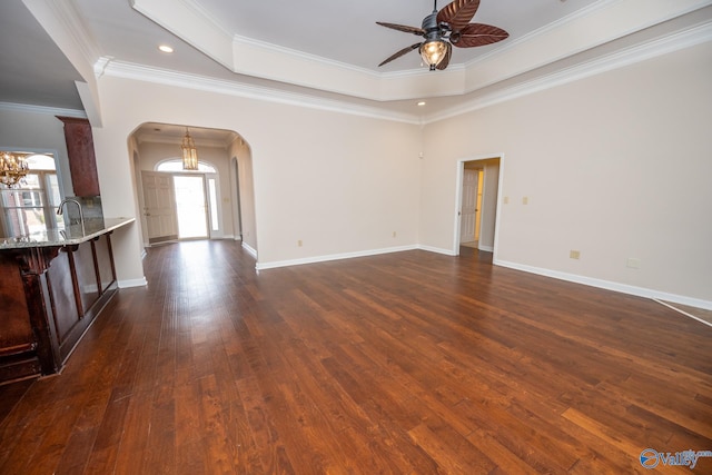 spare room with dark wood-style floors, baseboards, arched walkways, ornamental molding, and ceiling fan with notable chandelier