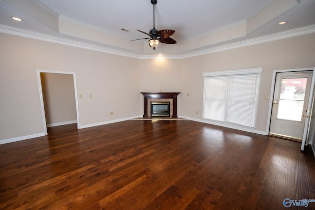 unfurnished living room featuring baseboards, dark wood-type flooring, ornamental molding, and a tiled fireplace