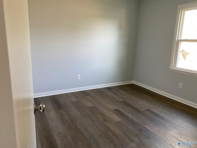 unfurnished room with dark hardwood / wood-style flooring