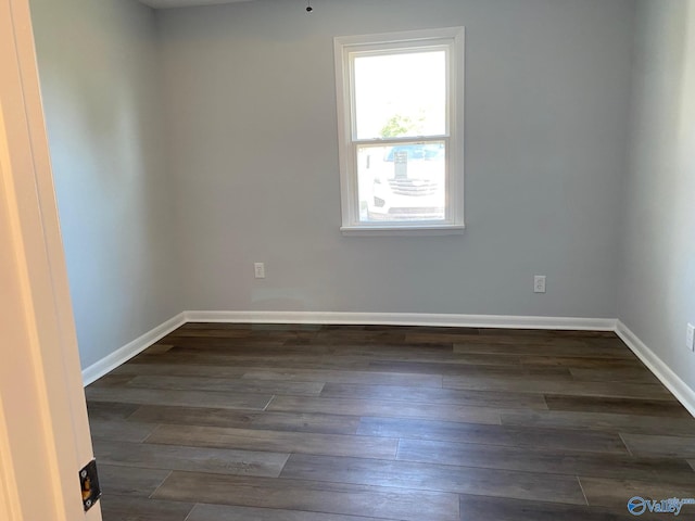 unfurnished room with dark wood-type flooring