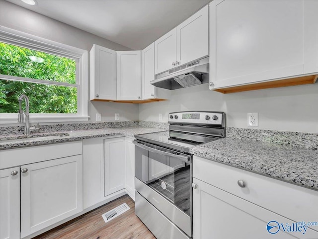 2612 Valley Brook Dr, Huntsville, AL 35811 - kitchen featuring stainless steel range with electric cooktop, under cabinet range hood, white cabinetry, light wood-type flooring, and light stone counters