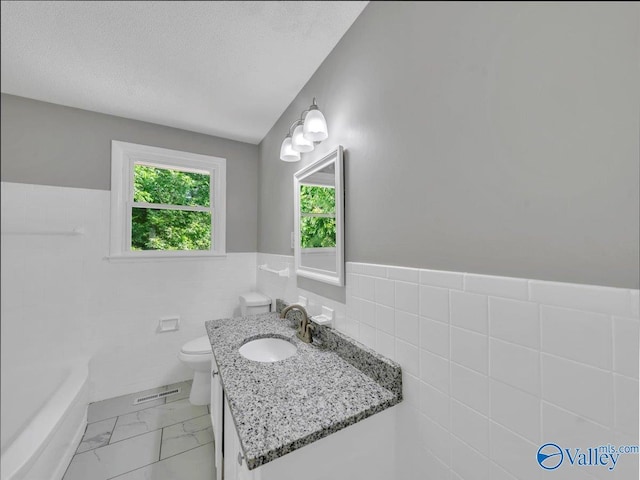 2612 Valley Brook Dr, Huntsville, AL 35811 - bathroom with tile walls, vanity, a tub to relax in, a wainscoted wall, and marble finish floors