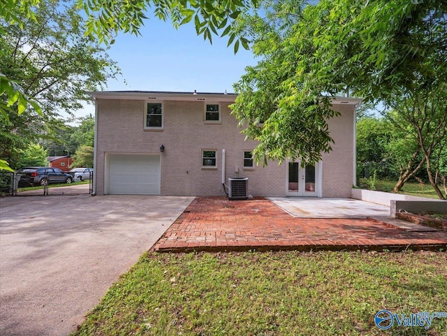 2612 Valley Brook Dr, Huntsville, AL 35811 - rear view of house featuring french doors, a garage, concrete driveway, a patio area, and brick siding