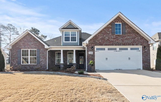 view of front facade featuring brick siding, a porch, an attached garage, driveway, and a front lawn