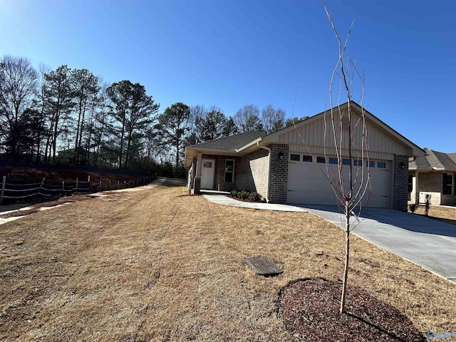 single story home featuring concrete driveway, a garage, and brick siding