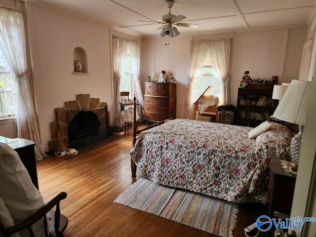 bedroom featuring a ceiling fan, ornamental molding, and wood finished floors