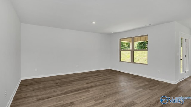 empty room with baseboards, dark wood finished floors, and recessed lighting