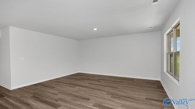 spare room featuring visible vents, baseboards, dark wood finished floors, and recessed lighting