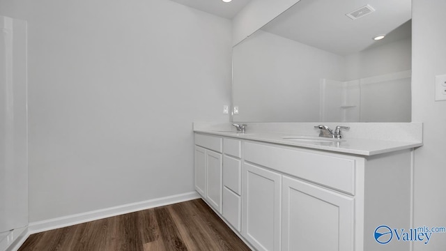 full bath featuring visible vents, a sink, baseboards, and wood finished floors