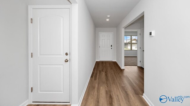 hall featuring baseboards and wood finished floors