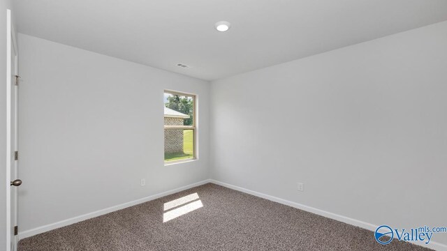 unfurnished room featuring carpet floors and baseboards