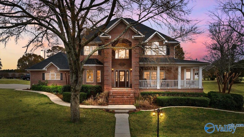 view of front of house with a yard and covered porch