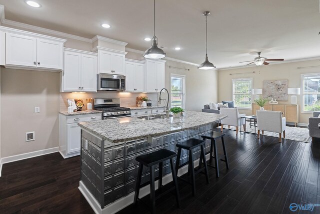 kitchen with appliances with stainless steel finishes, sink, white cabinets, and backsplash