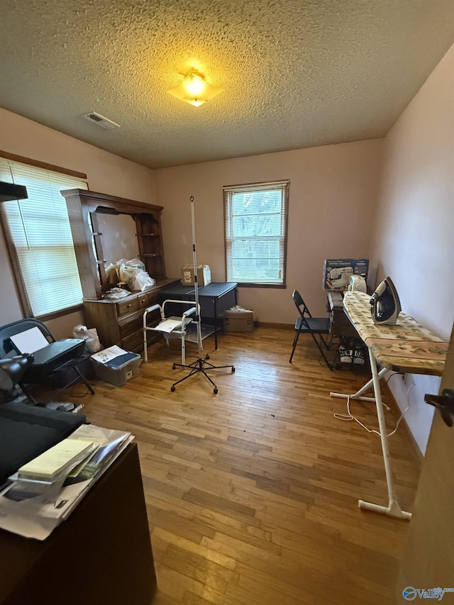 office with a textured ceiling and light hardwood / wood-style floors