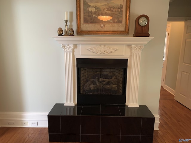 interior details featuring a fireplace, baseboards, and wood finished floors