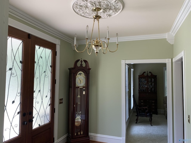 carpeted entryway with a notable chandelier, baseboards, crown molding, and french doors