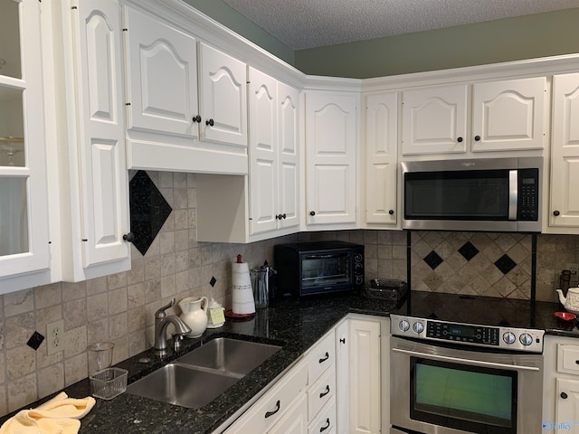 kitchen featuring stainless steel appliances, a sink, and white cabinets