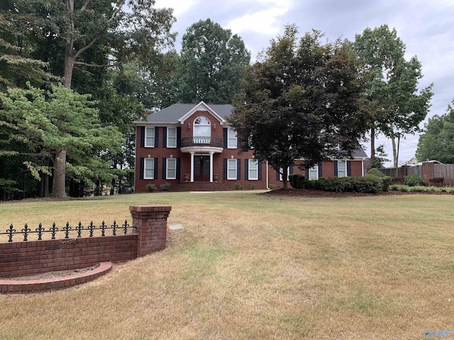 view of front of property with brick siding, fence, and a front yard