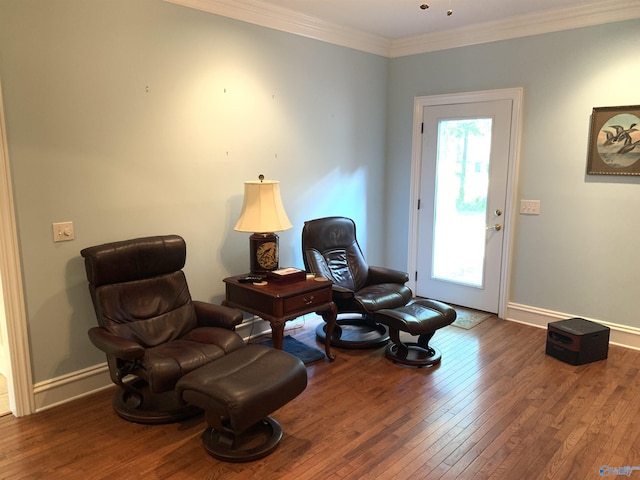 sitting room featuring baseboards, hardwood / wood-style floors, and crown molding