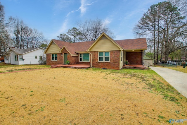 single story home with brick siding, concrete driveway, a shingled roof, and a front lawn
