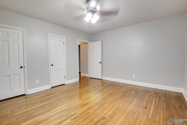 unfurnished bedroom featuring baseboards, light wood-style flooring, and a ceiling fan