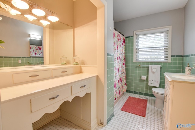 full bath featuring tile patterned floors, toilet, vanity, visible vents, and tile walls