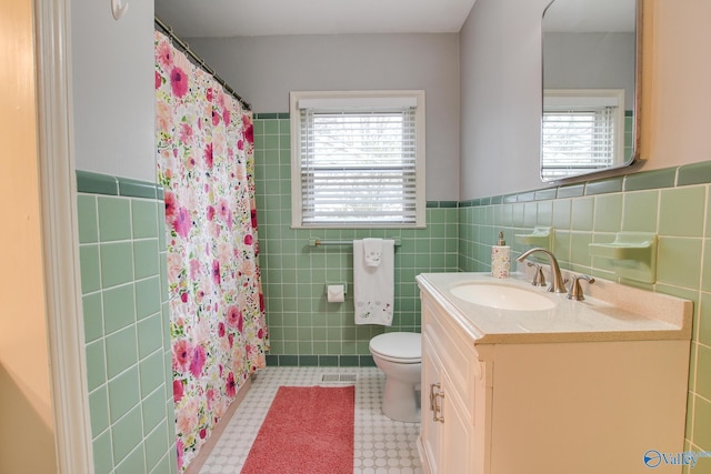 bathroom featuring tile walls, toilet, and plenty of natural light