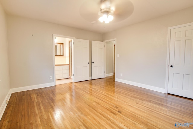 unfurnished bedroom with ensuite bathroom, baseboards, ceiling fan, and light wood-type flooring