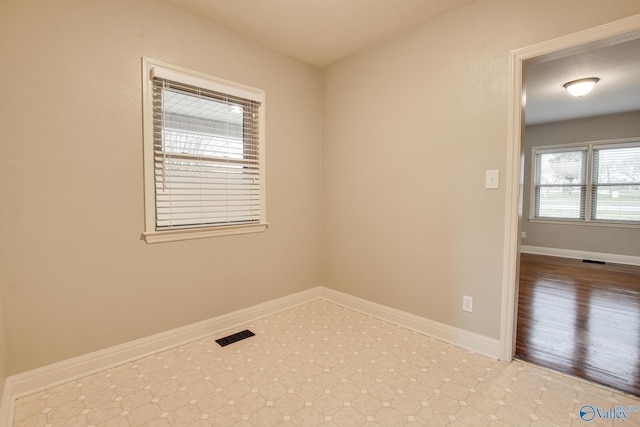 unfurnished room with baseboards, visible vents, and tile patterned floors
