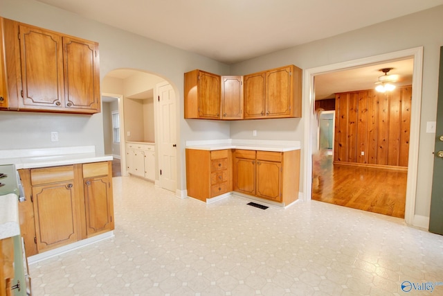 kitchen with light countertops, visible vents, arched walkways, and light floors